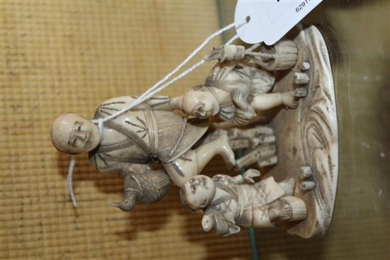 A Japanese carved ivory okimono group of street vendors, Meiji period,(-)